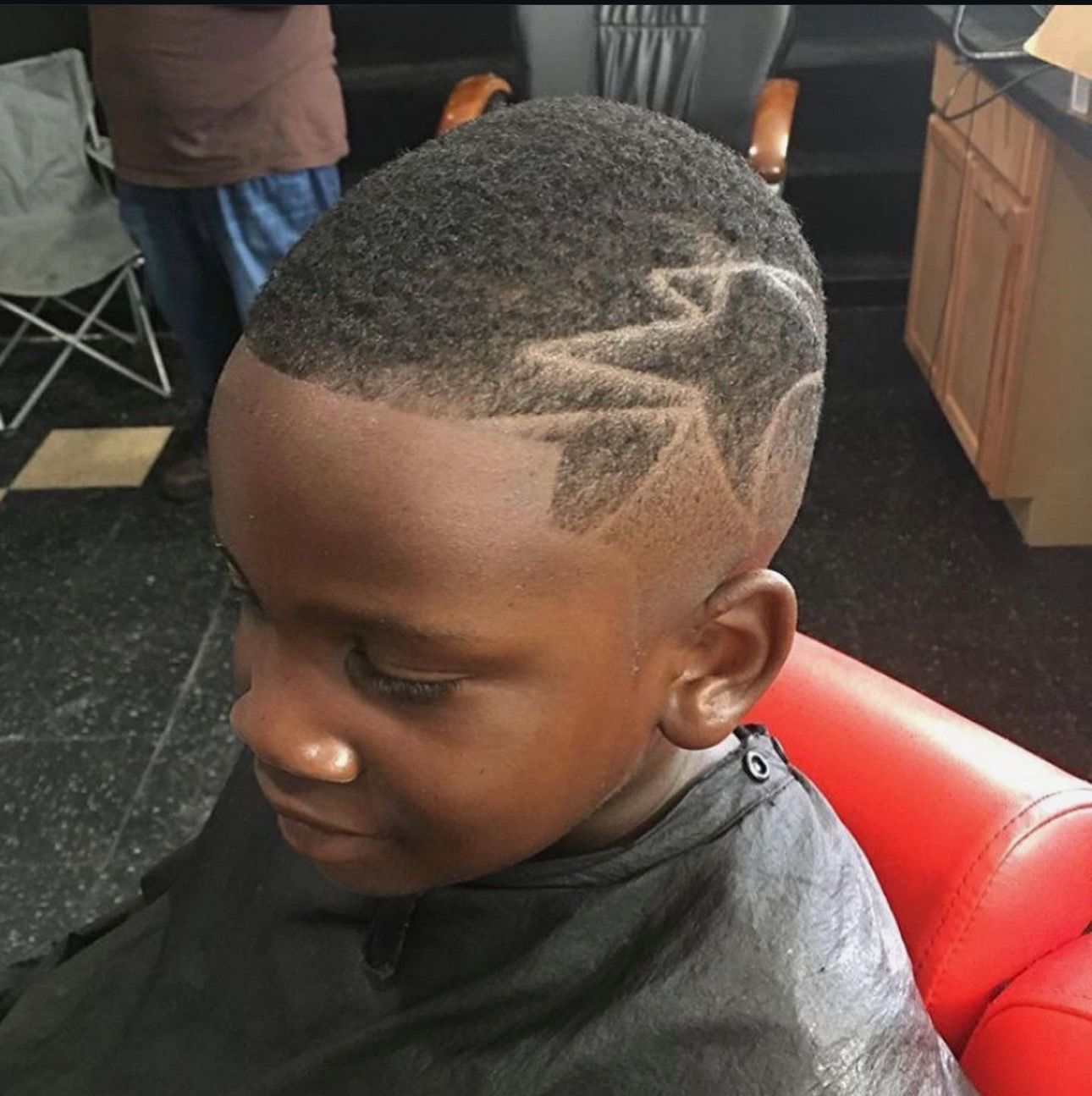 A young boy is getting his hair cut at a barber shop