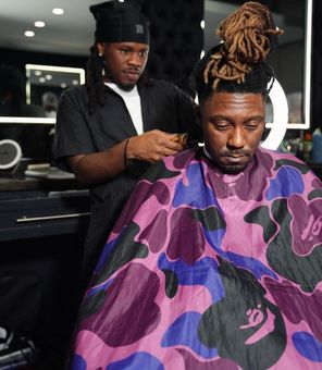 A man is getting his hair cut at a barber shop