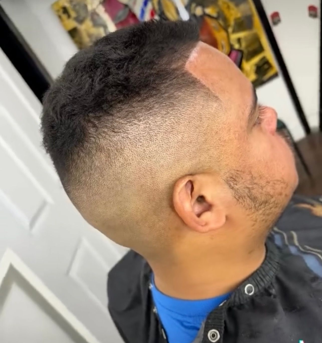 A man is getting his hair cut at a barber shop.