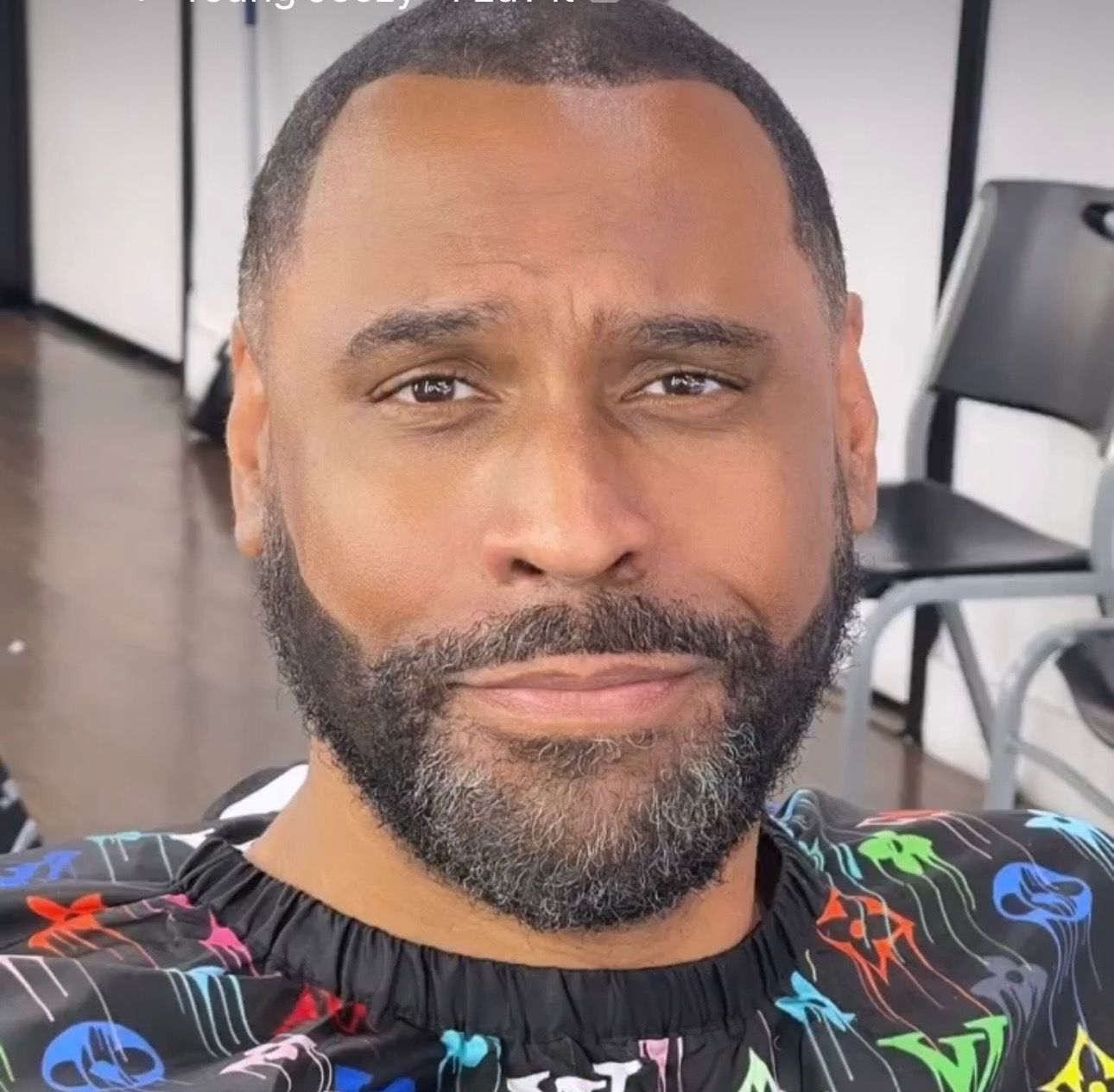 A man with a beard is wearing a louis vuitton apron