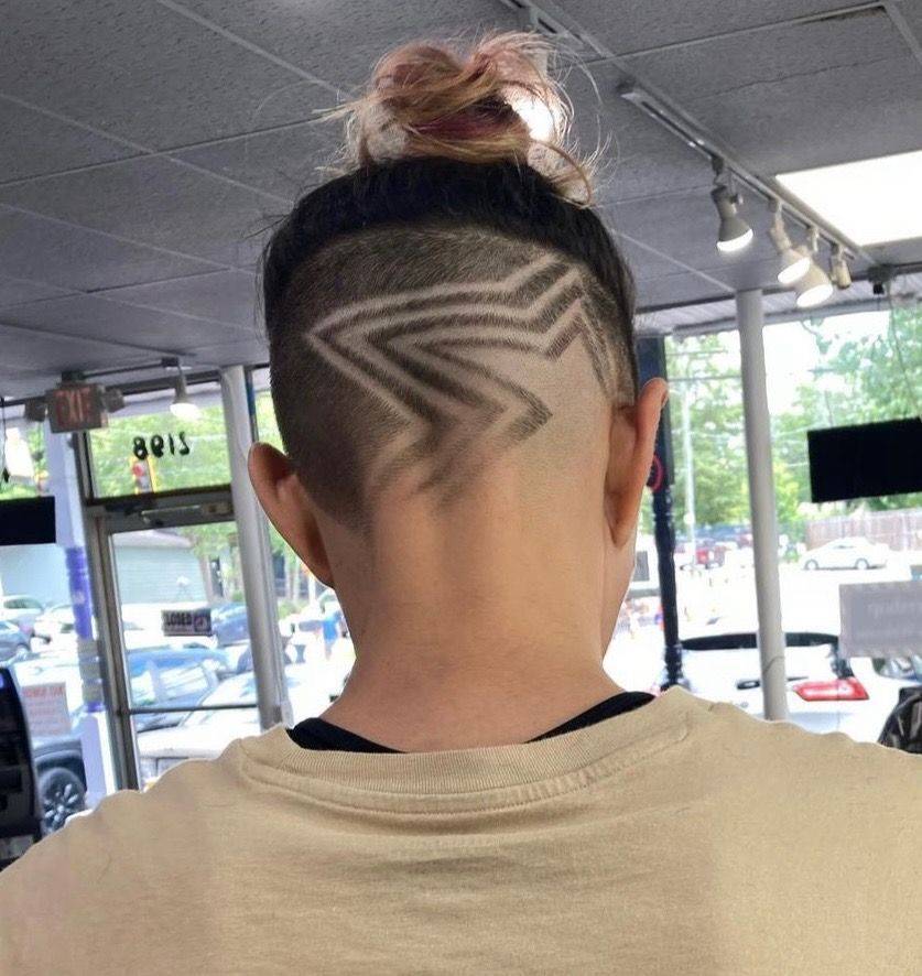 The back of a person 's head with a shaved design on it