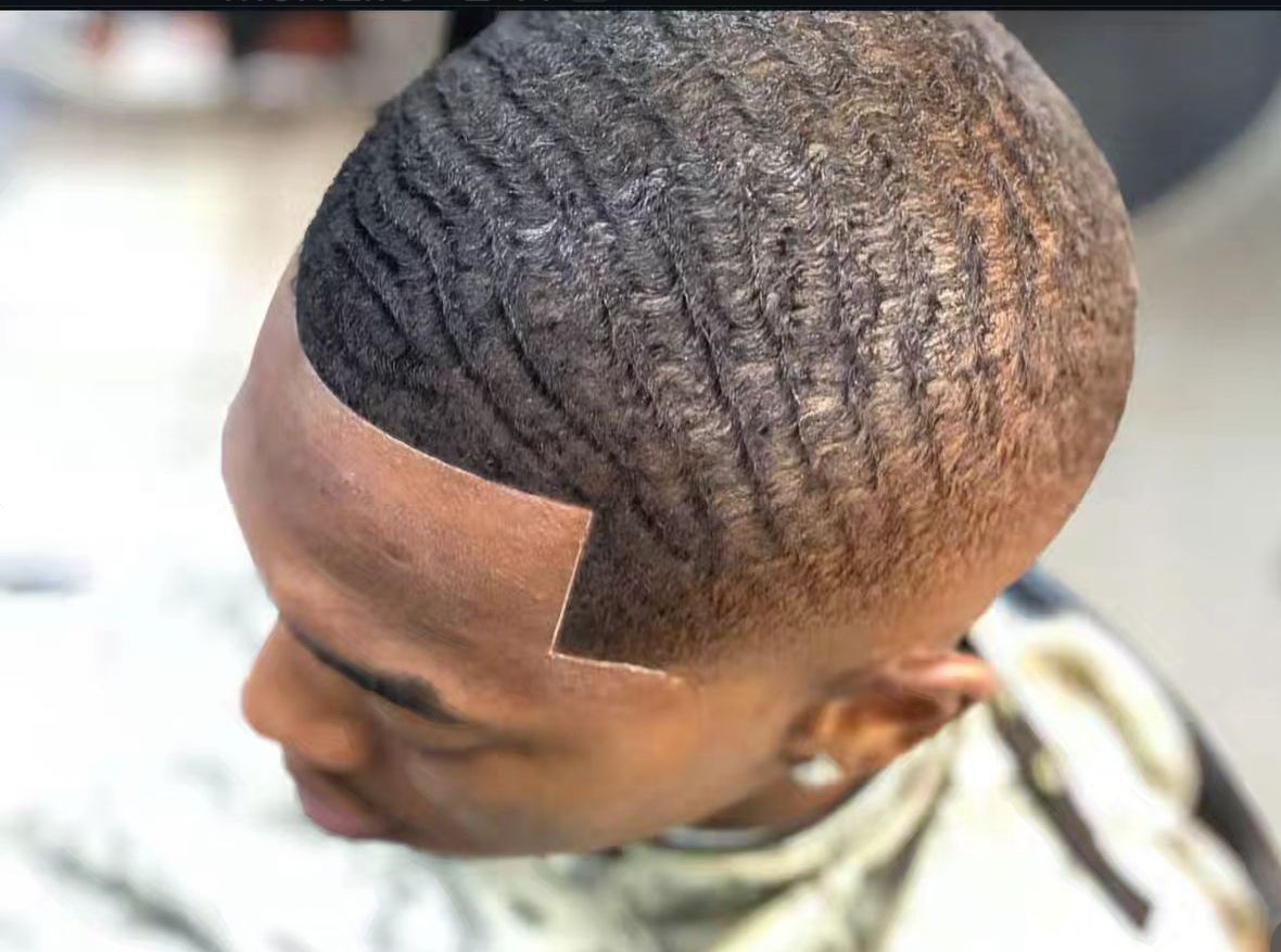 A man is getting his hair cut at a barber shop.