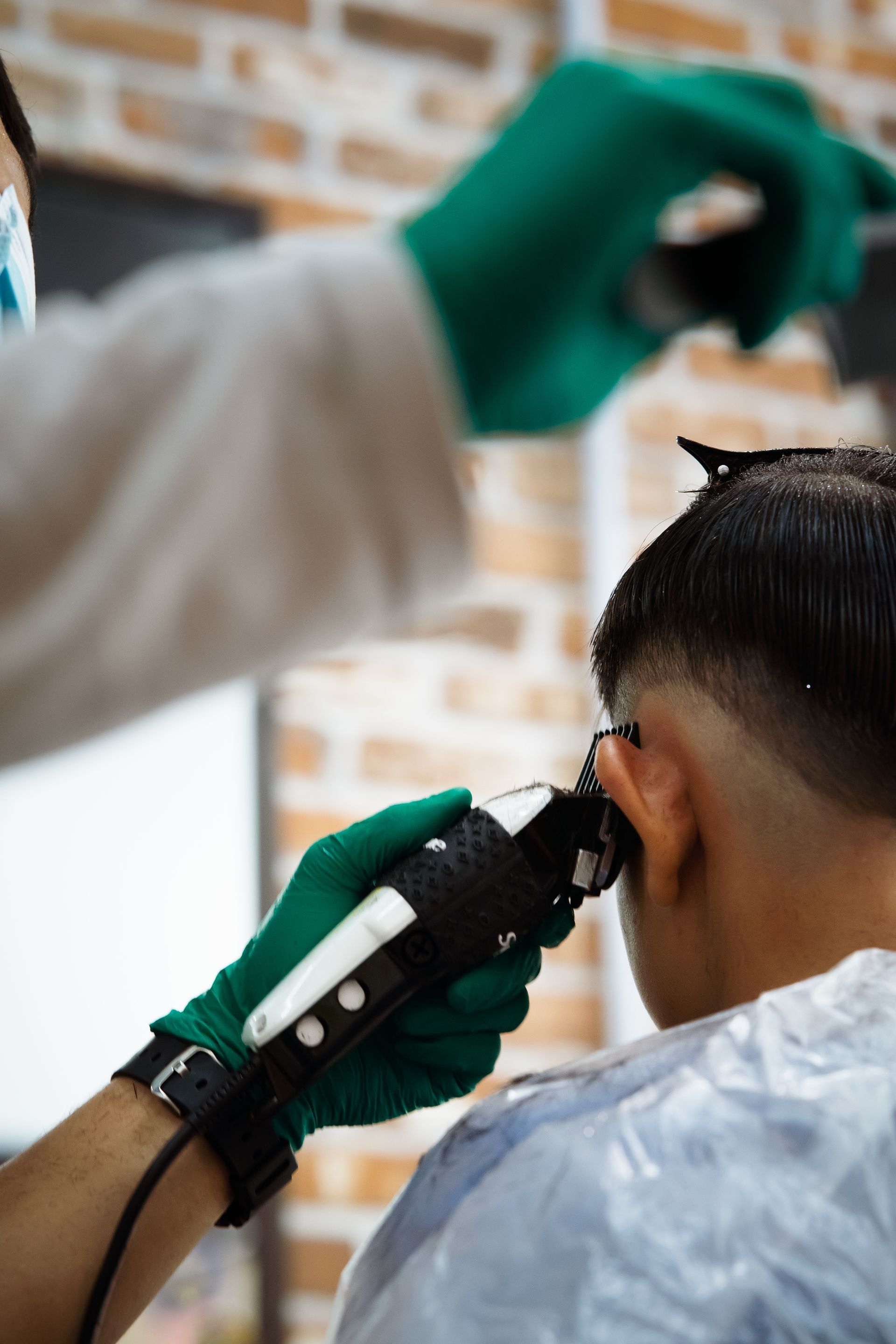A man is getting his hair cut by a barber in a barber shop.