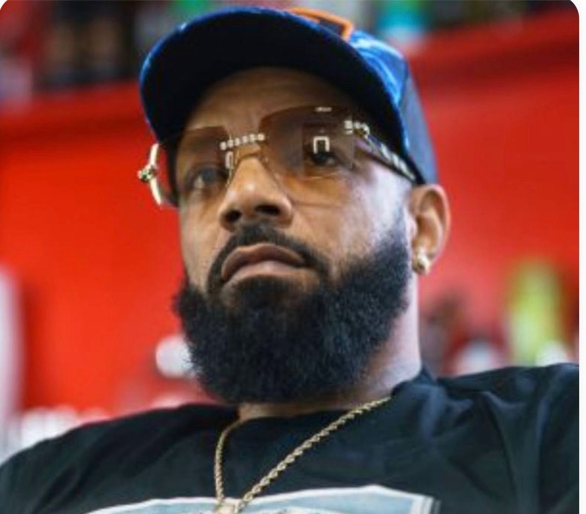 A man with a beard wearing sunglasses and a hat.