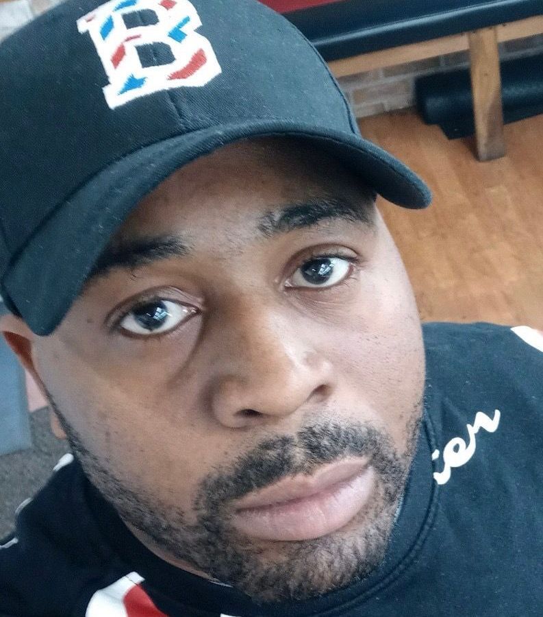 A man wearing a baseball cap with the letter b on it