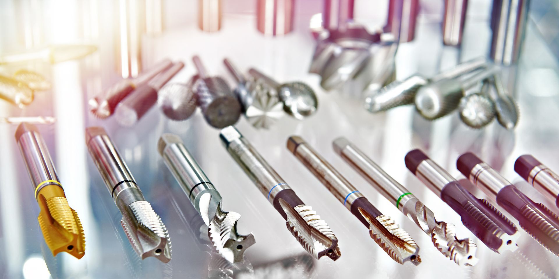 Metalworking tools arranged on a reflective surface, likely in a shop or display.