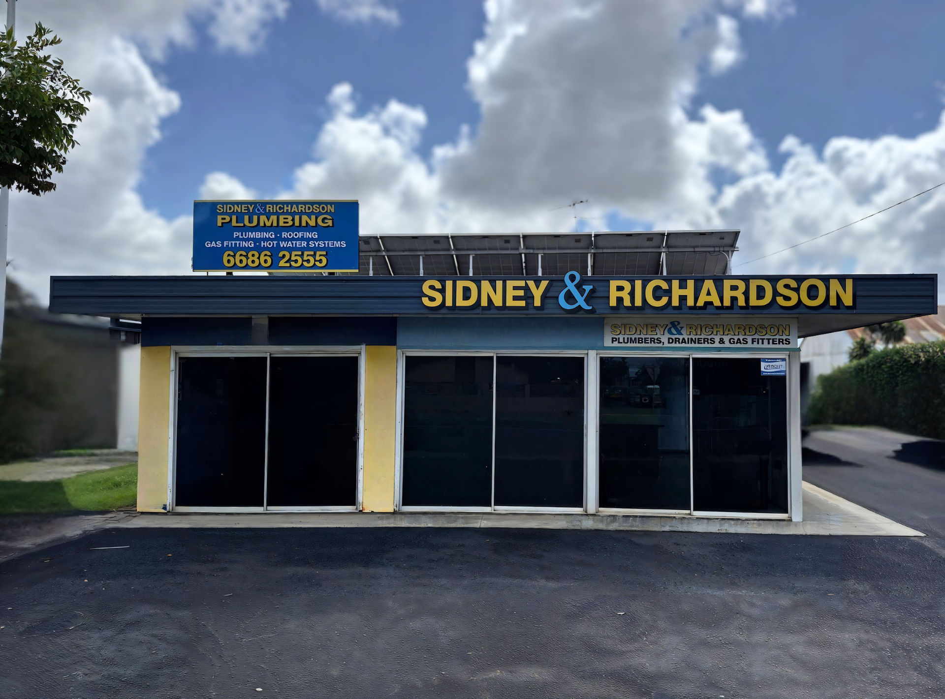 Sidney & Richardson plumbing shop exterior with blue sign and cloudy sky