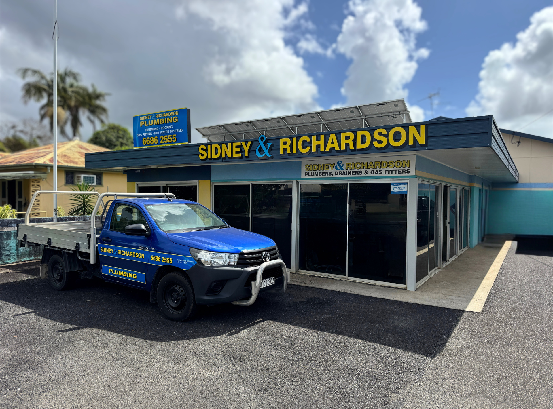 Sidney & Richardson plumbing storefront with blue awning and parking lot under cloudy sky