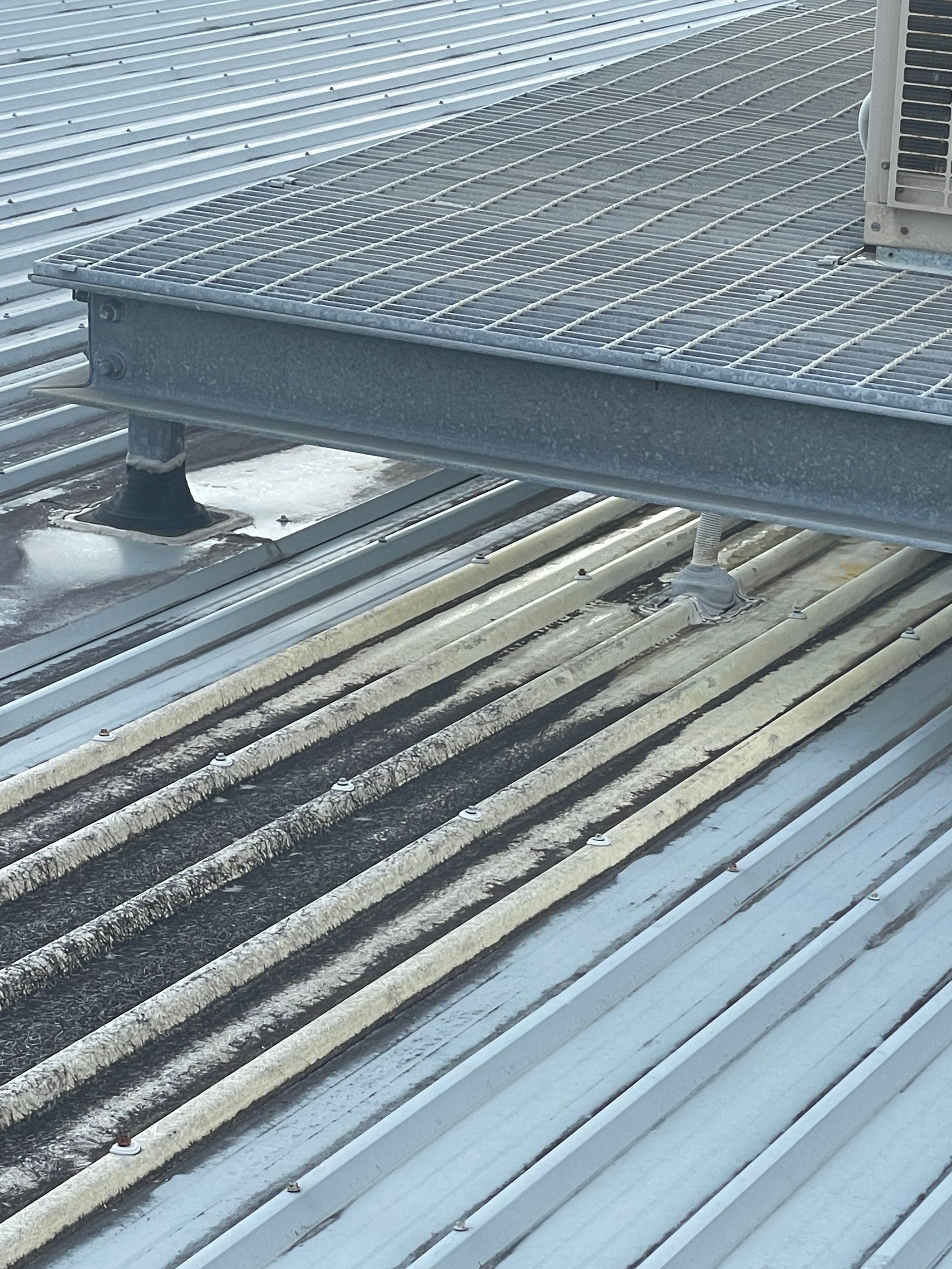 Stacked metal grating panels and beams in an industrial storage area