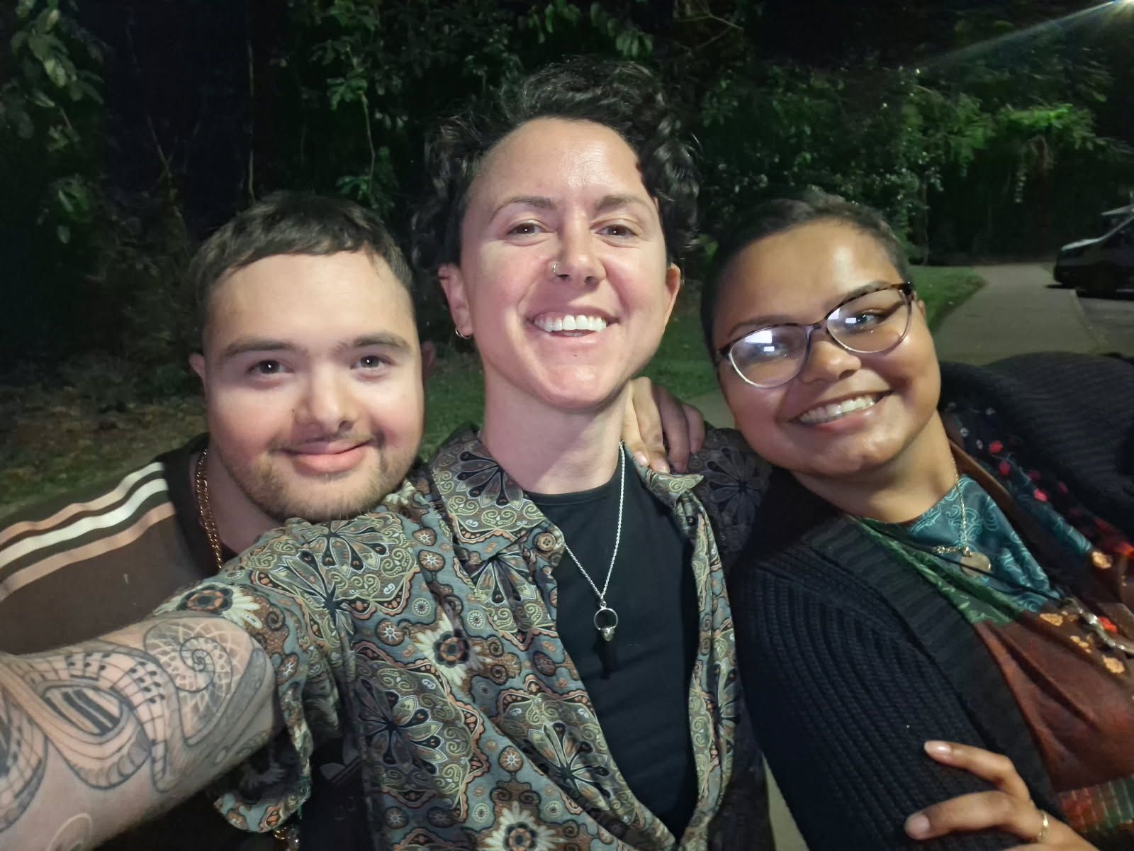 Three Smiling Friends Taking a Nighttime Selfie Outdoors — Sparks Social Abilities in Bungalow, QLD