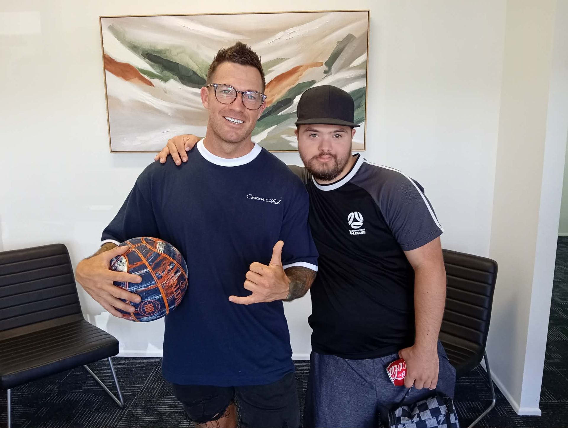 Two Men Posing Indoors, One Holding a Basketball — Sparks Social Abilities in Bungalow, QLD