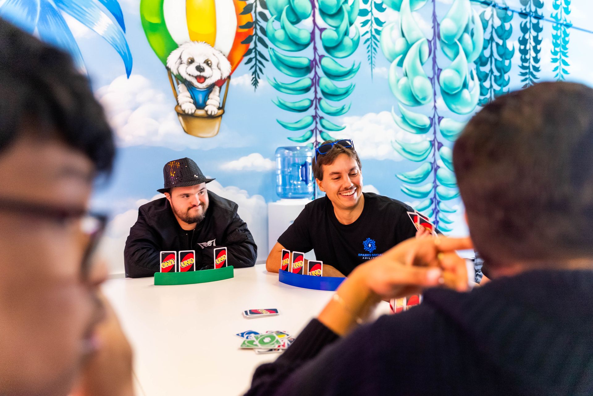 Two Men Playing a Card Game at a Table — Sparks Social Abilities in Bungalow, QLD