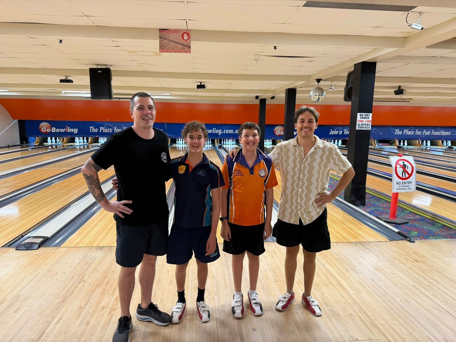 Four People Posing Together at a Bowling Alley — Sparks Social Abilities in Bungalow, QLD
