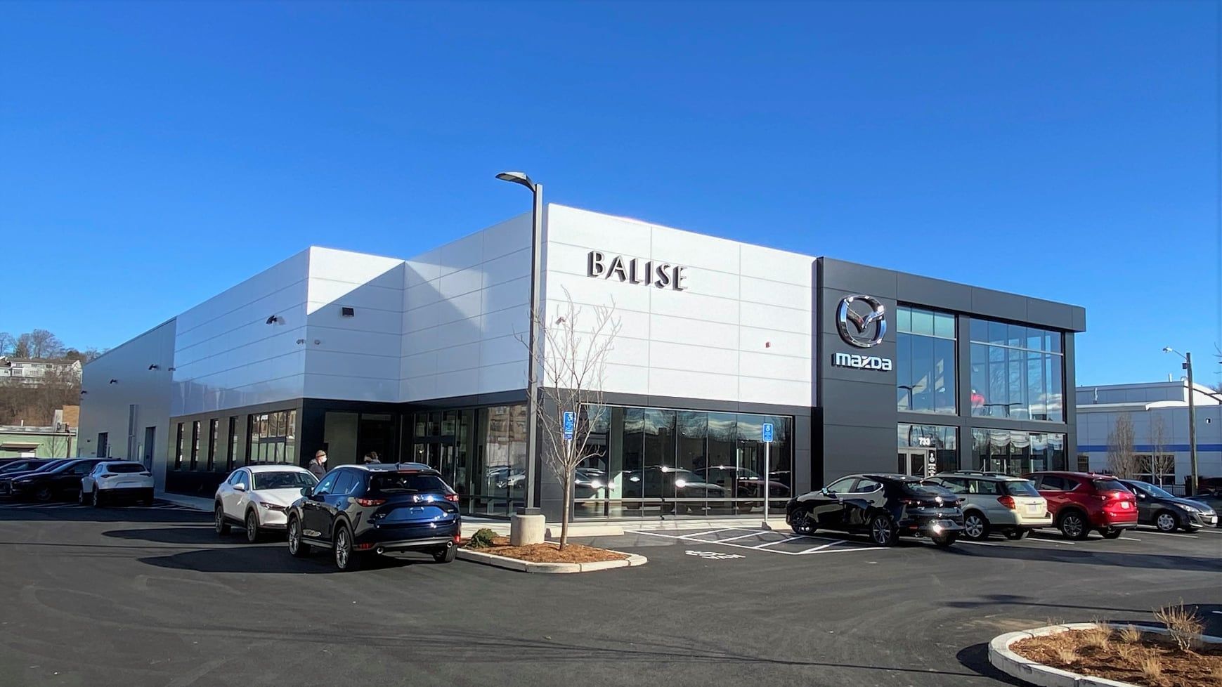 A toyota dealership with a lot of cars parked in front of it.