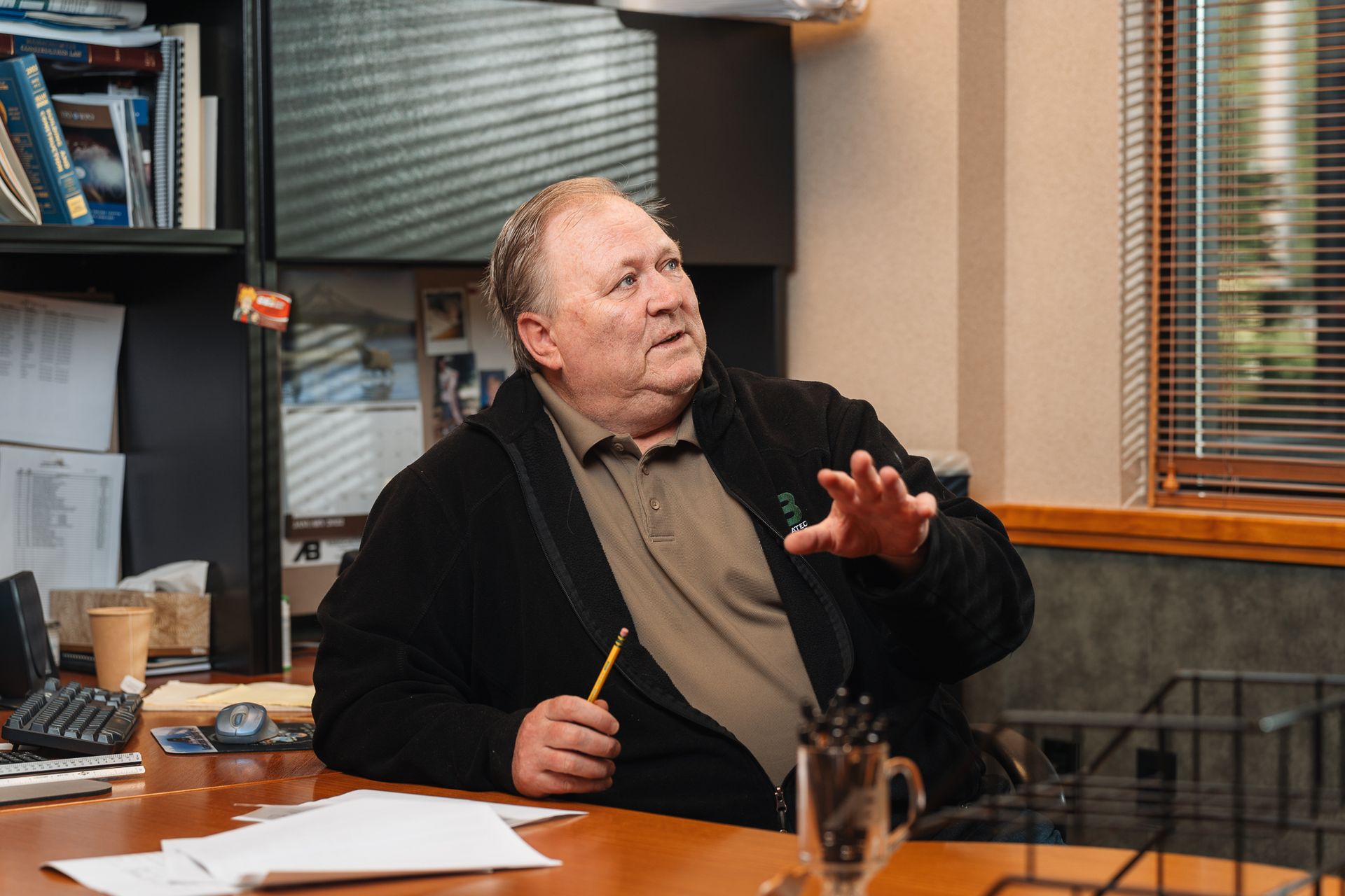 A man is sitting at a table with a pen in his hand.