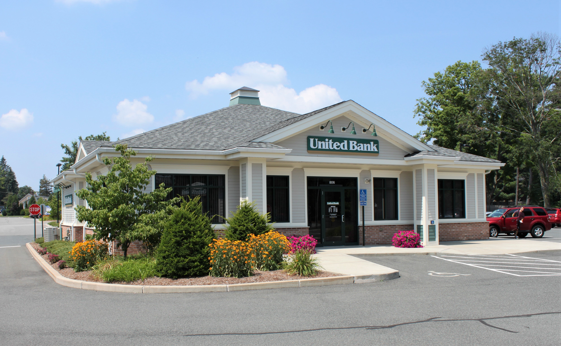 A united bank building with cars parked in front of it