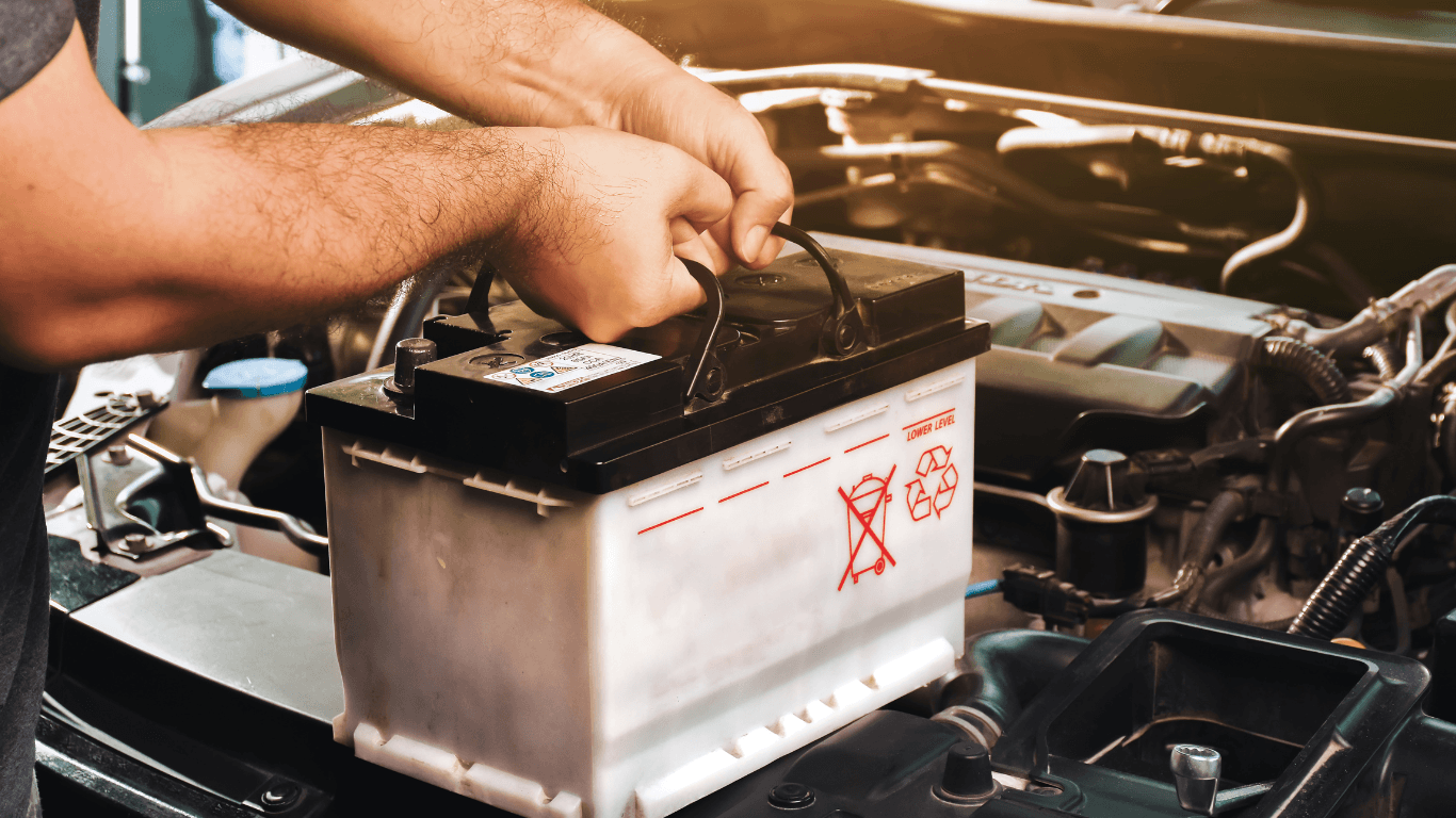 a picture of a mechanic replacing a car battery