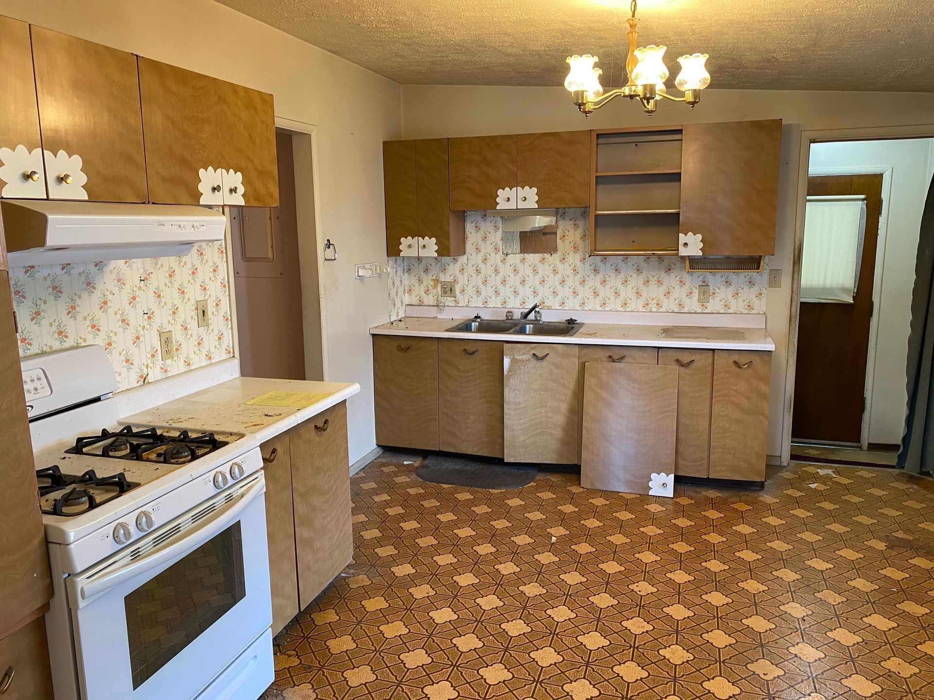 An empty kitchen with a stove and a sink