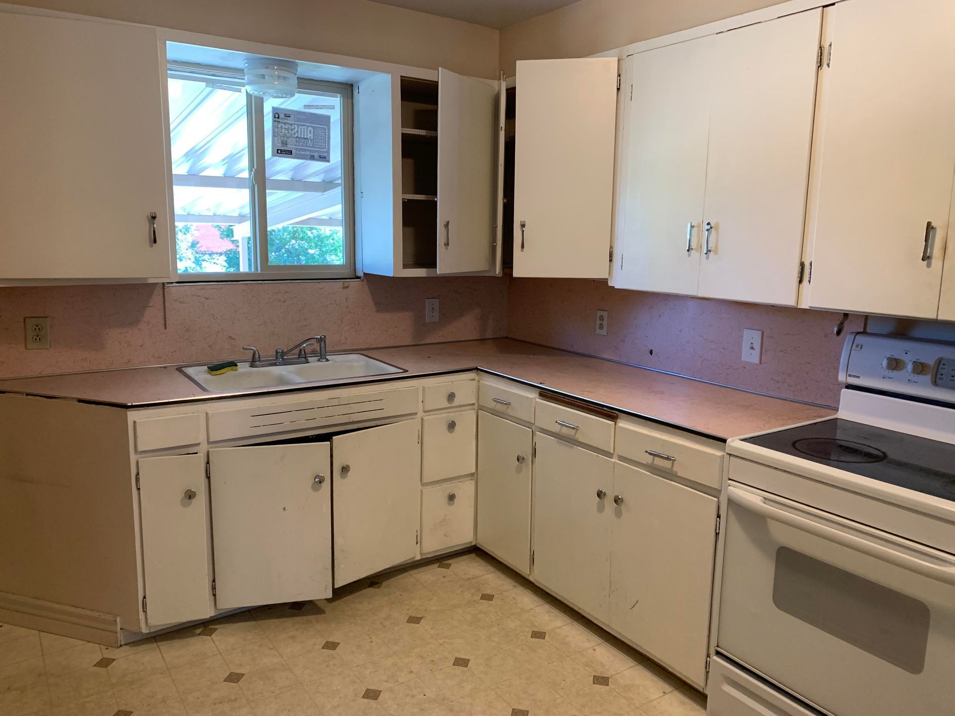 A kitchen with white cabinets and a white stove