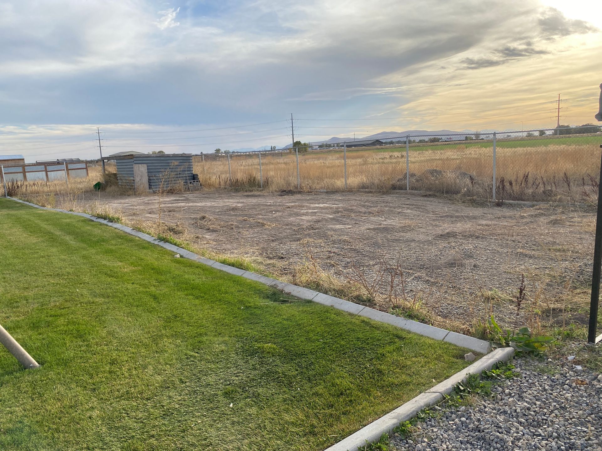 A grassy field with a gravel path going through it.