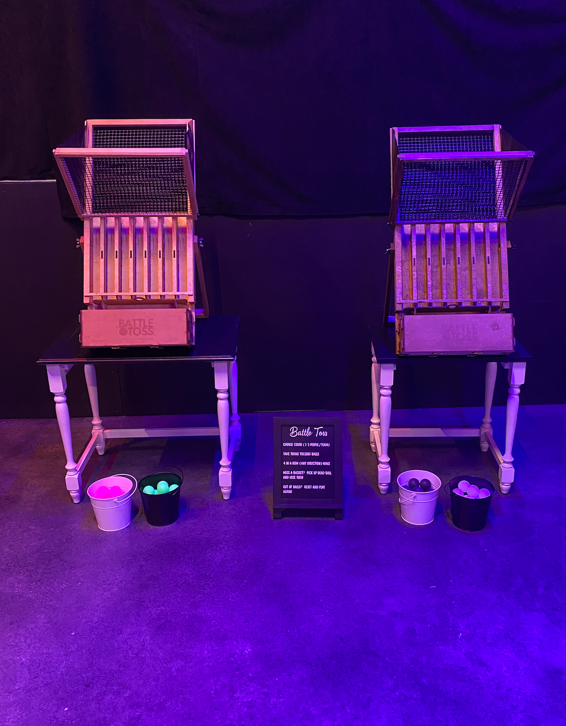 Two chairs are sitting next to each other in a room with purple lights.