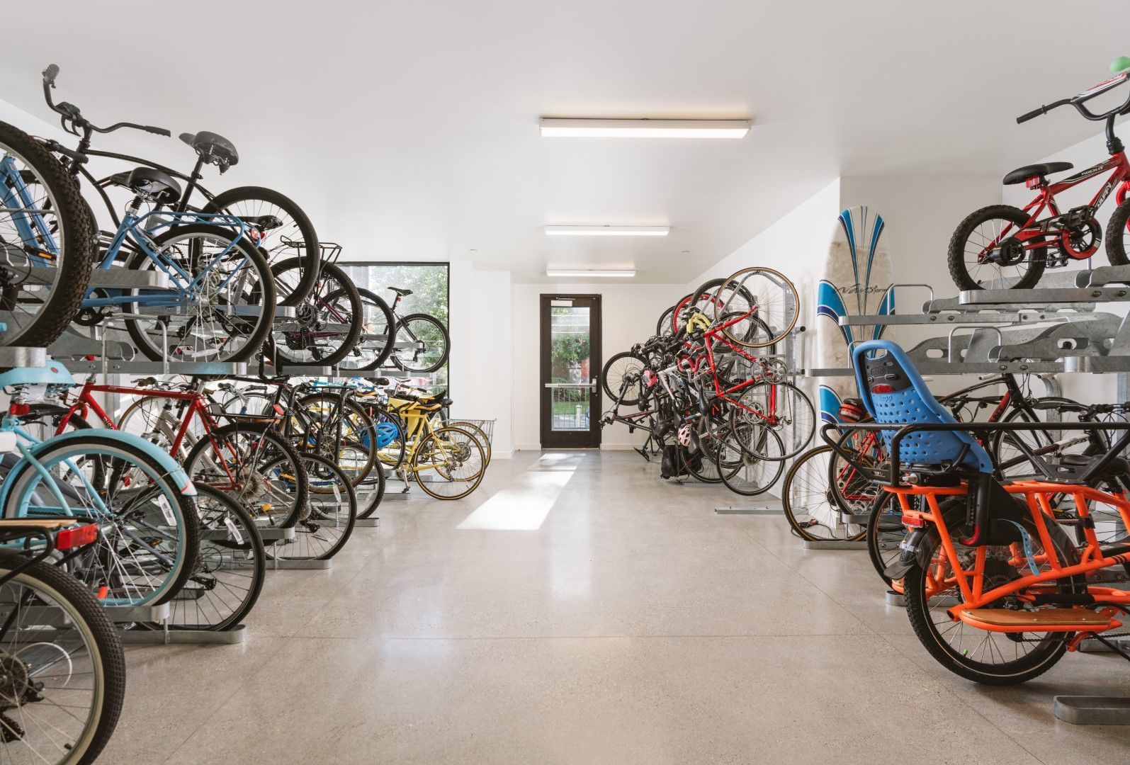A large room filled with lots of bicycles on racks.