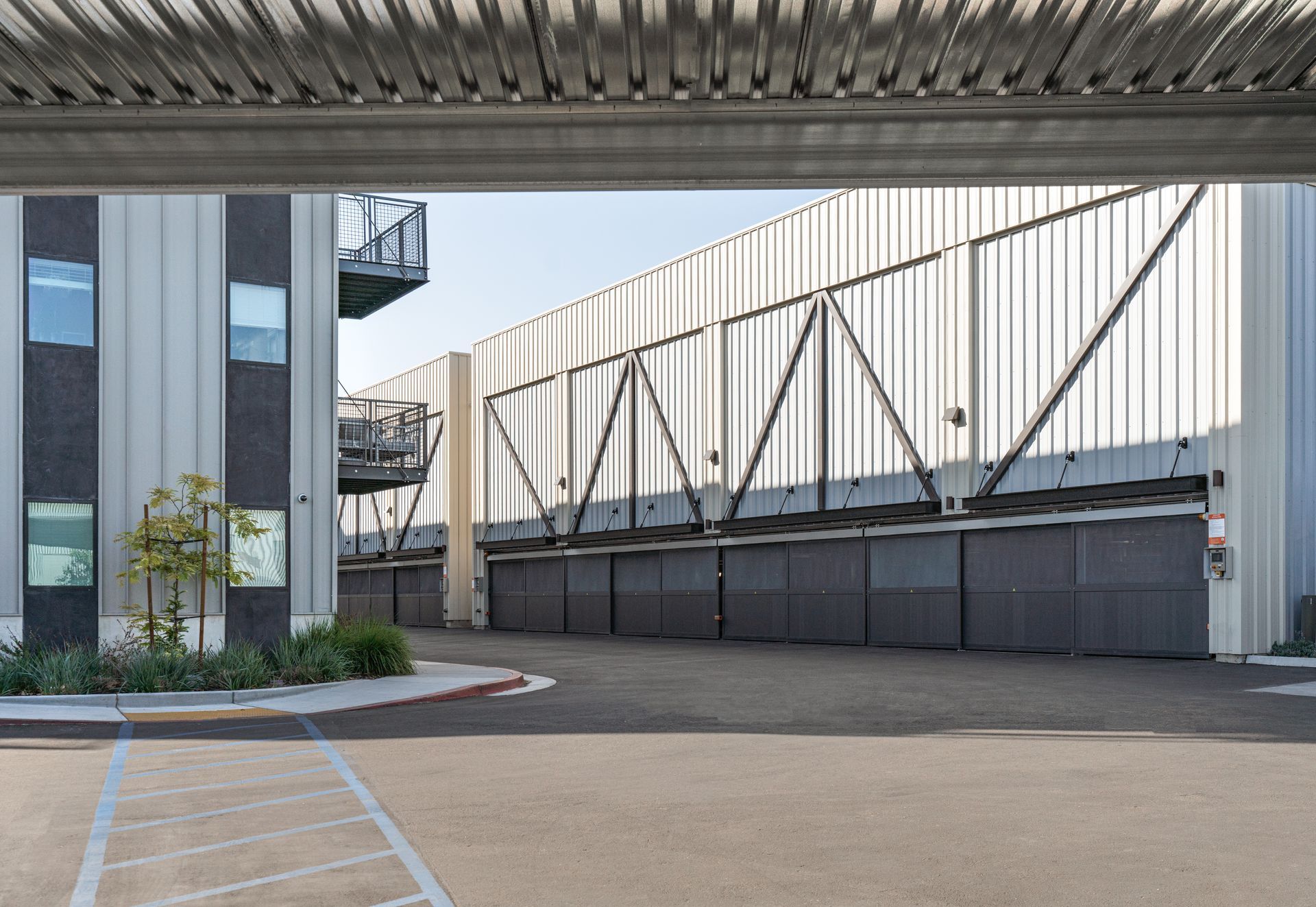 A building with a lot of garage doors and a handicapped parking spot in front of it.