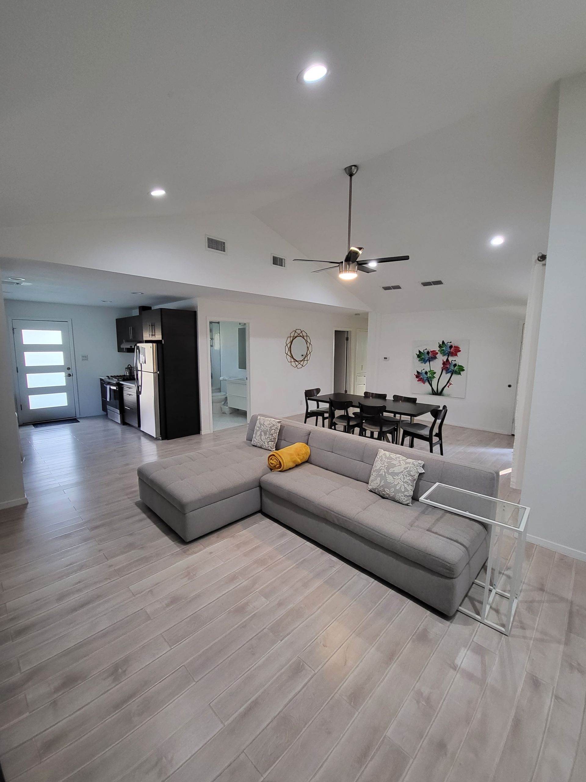 A living room with a couch and a ceiling fan.