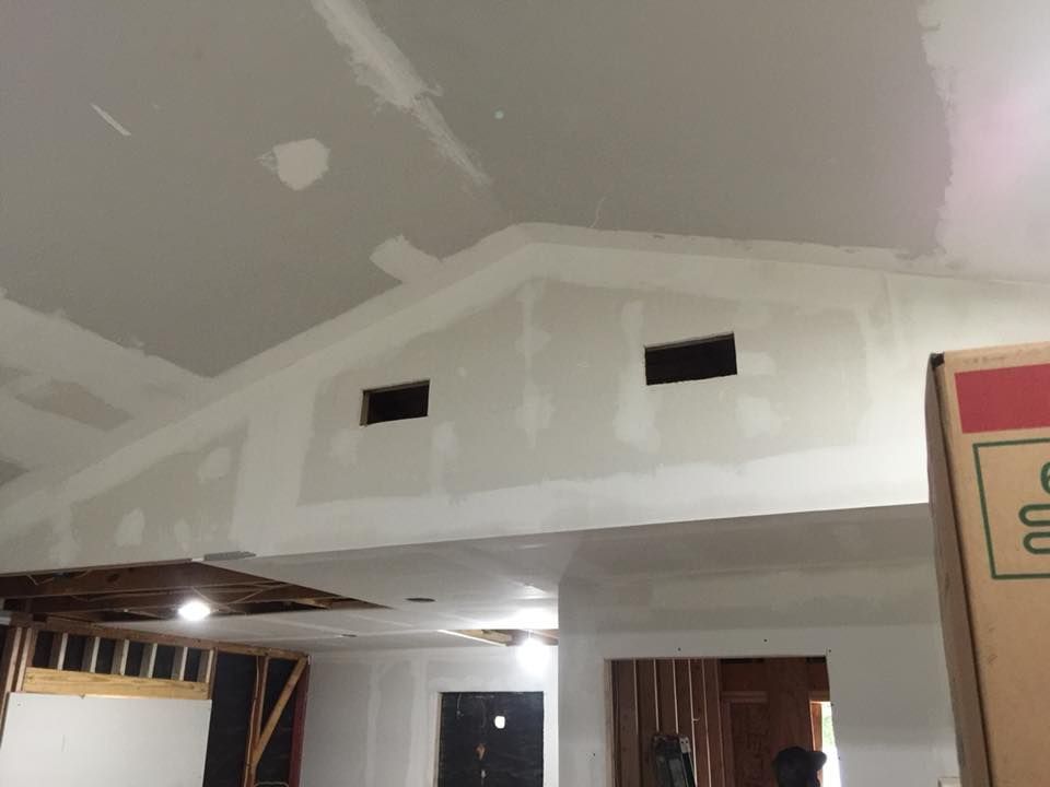 Partially finished room with drywall, ceiling patches, and exposed wiring above a doorway