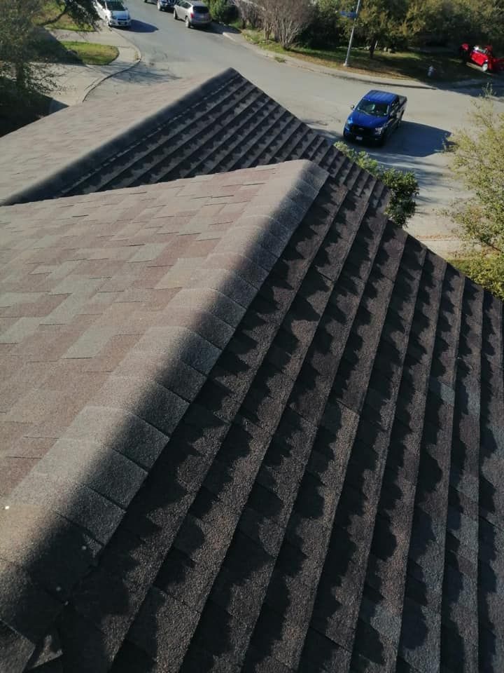 A car is driving down a street next to a roof.