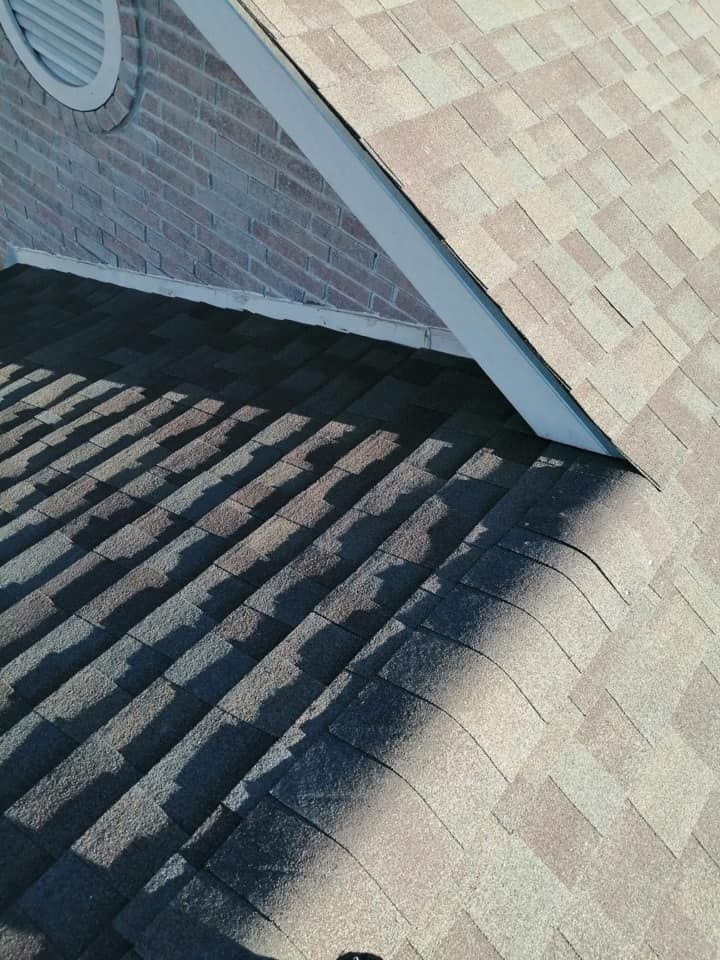 Roof shingles and siding with striped shadows from a nearby structure.