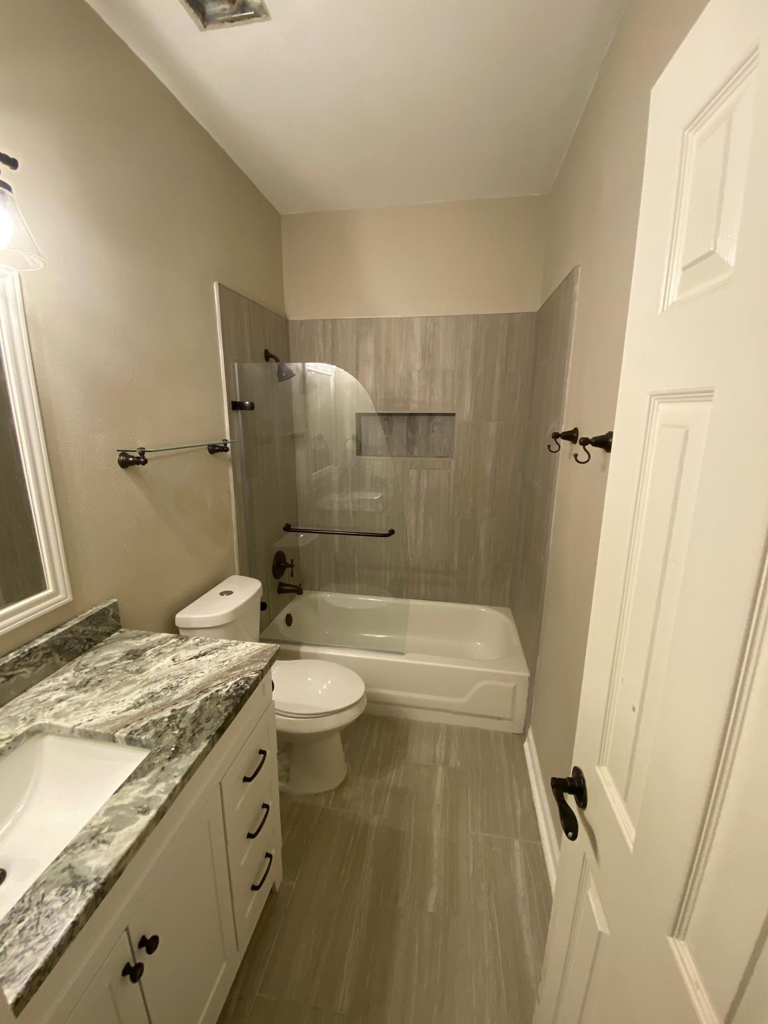 A bathroom with a toilet , sink , bathtub and shower.