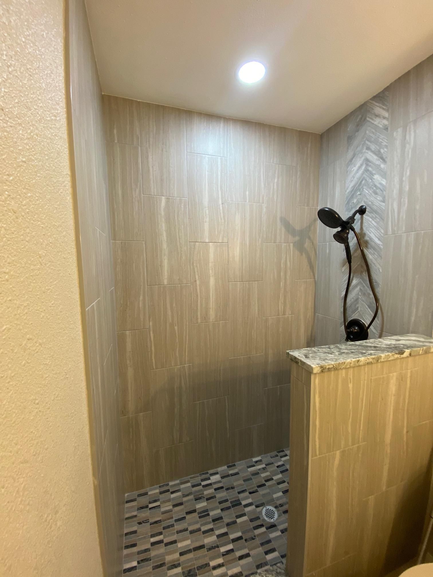 A bathroom with a walk in shower and a toilet.