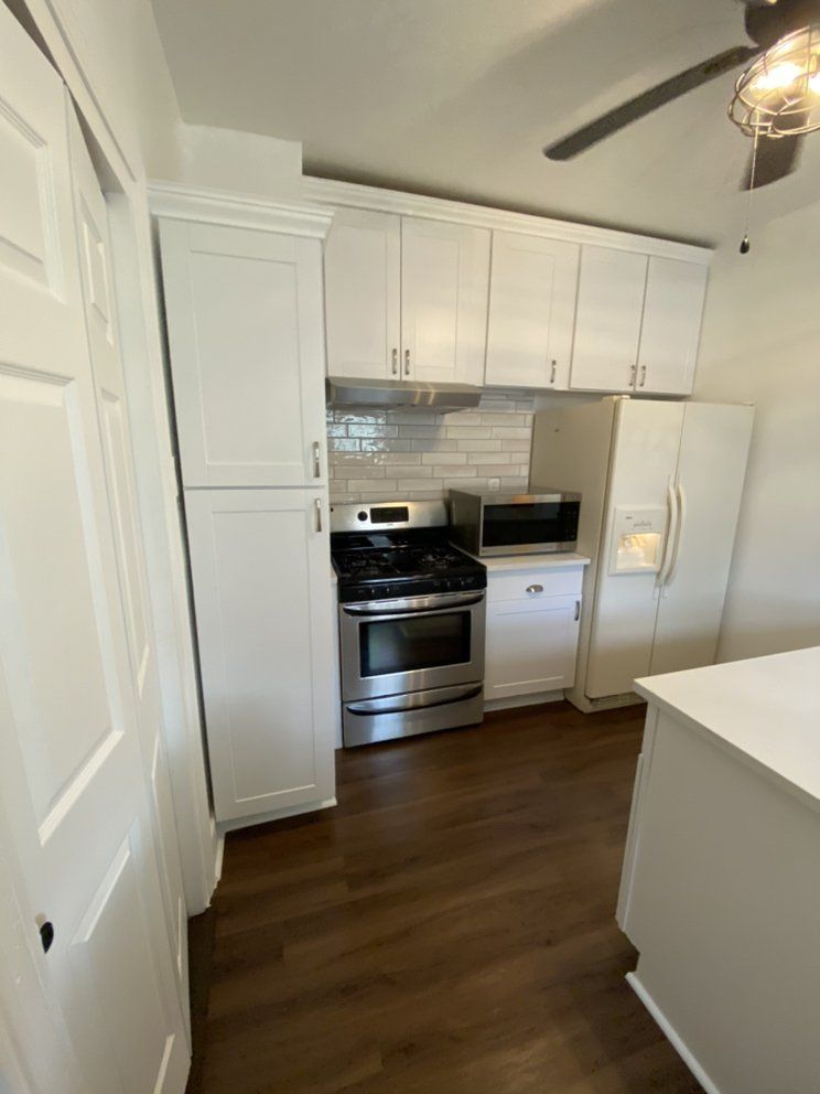 A kitchen with black cabinets and white counter tops