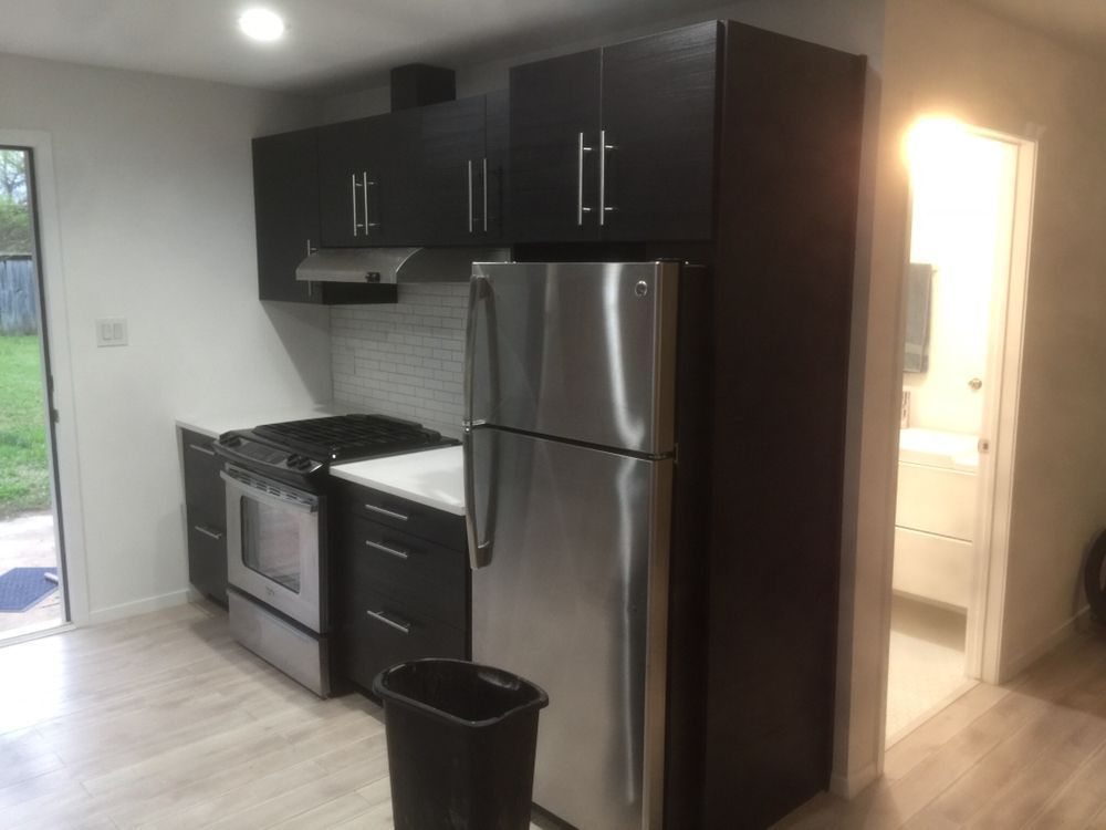 A kitchen with stainless steel appliances and black cabinets
