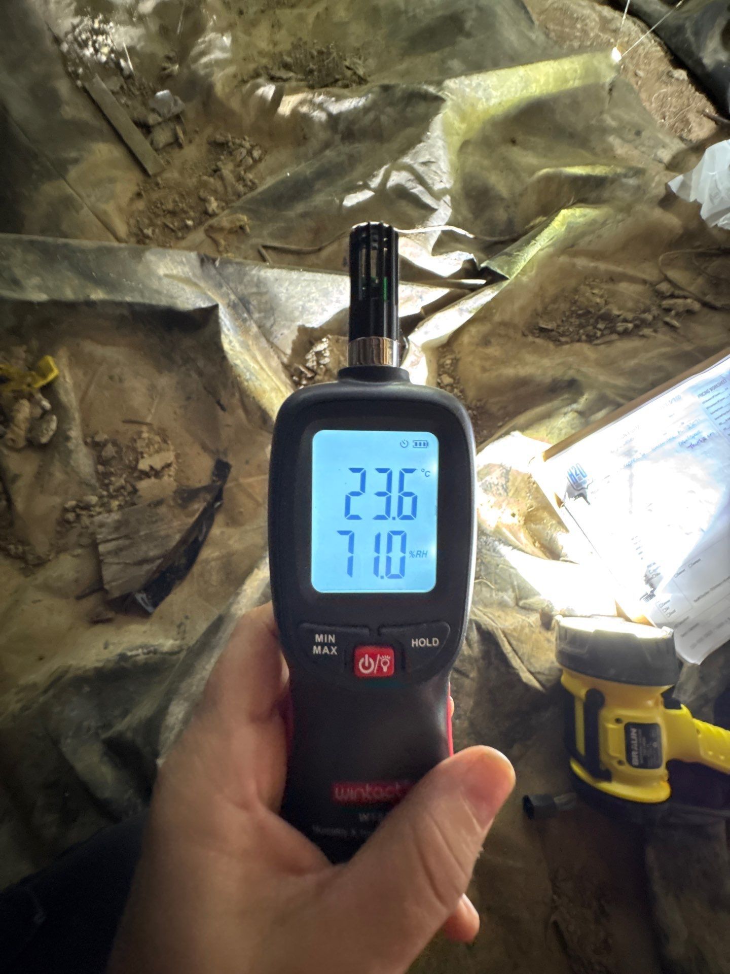 Humidity meter showing 71 percent relative humidity in the crawl space before encapsulation