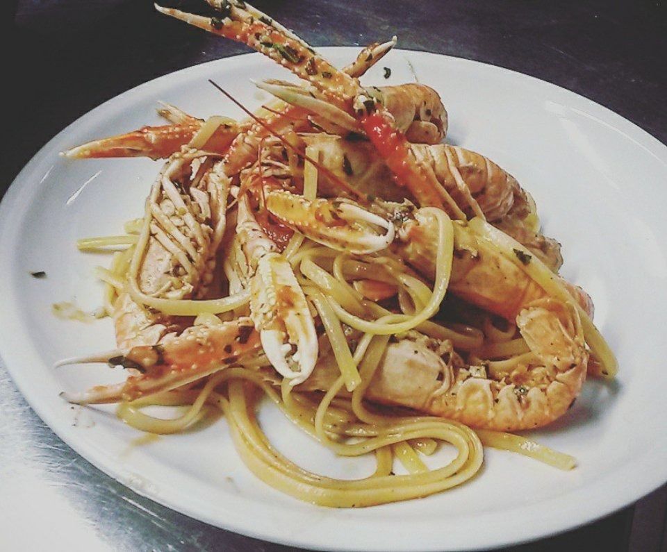 Plate of shrimp pasta with spaghetti and lemon strips on a white dish