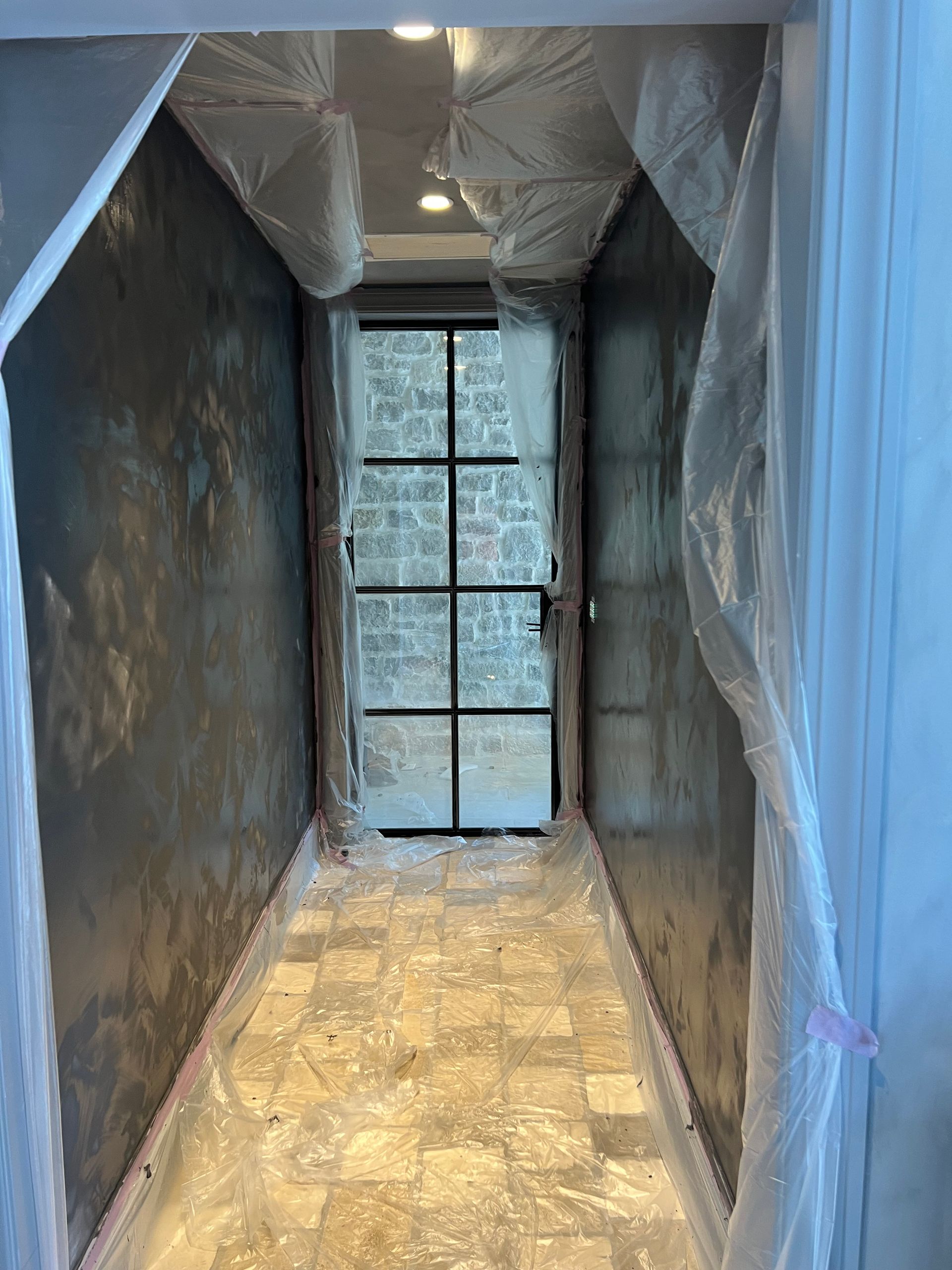 A hallway with a door and walls covered in plastic.