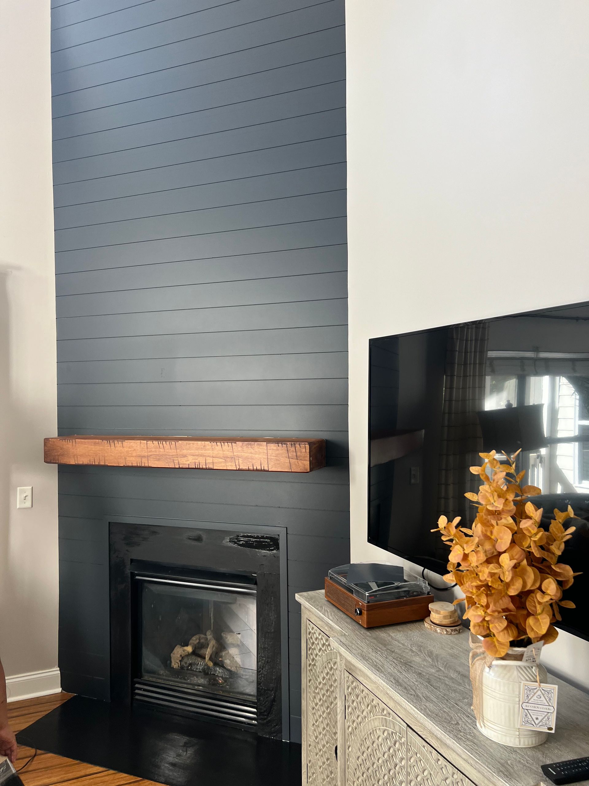A living room with a fireplace and a flat screen tv.