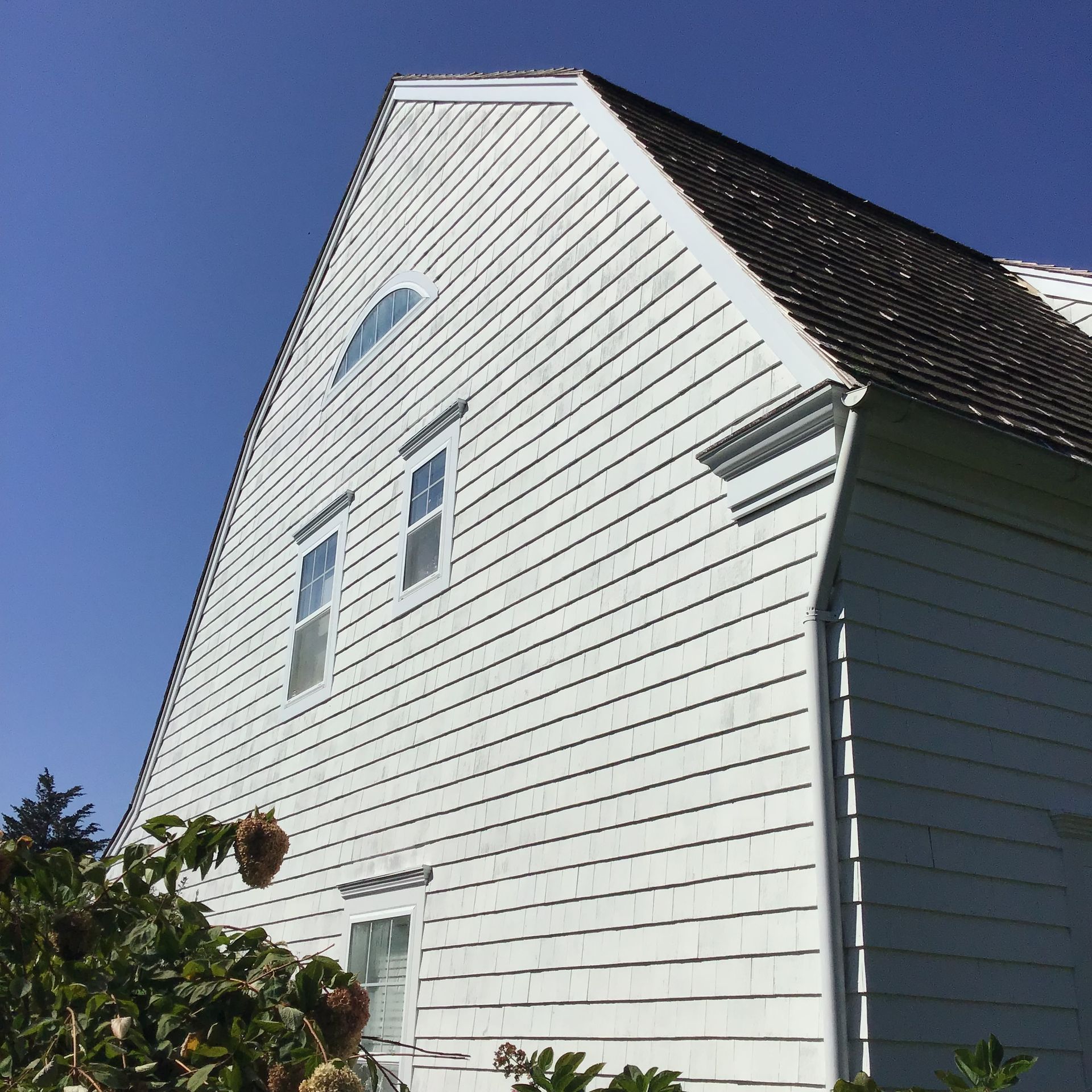 A large white house with a triangle shaped roof