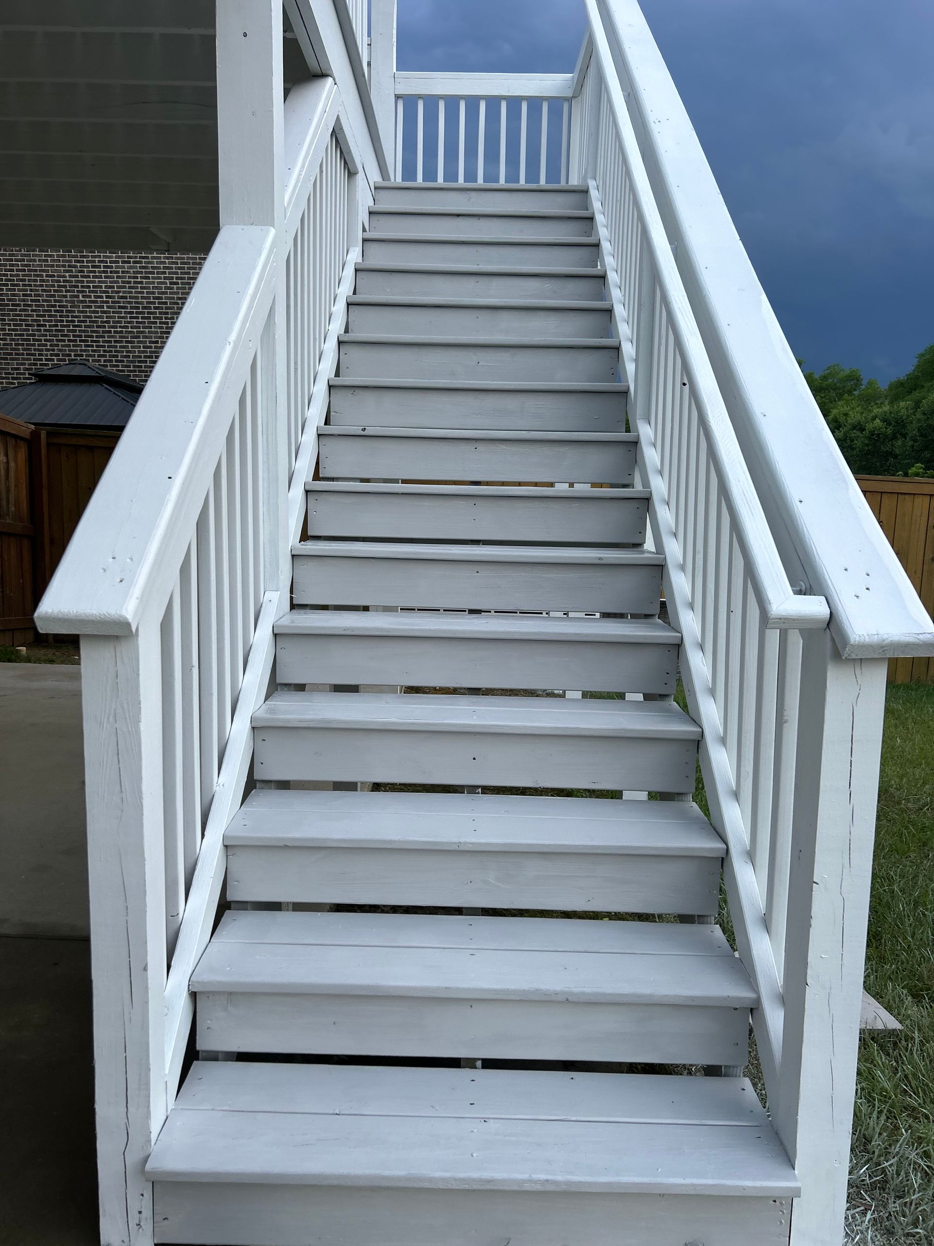 A set of stairs leading up to a deck with a white railing
