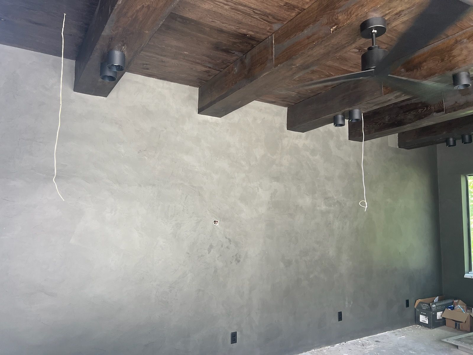 A room with a wooden ceiling and a ceiling fan.