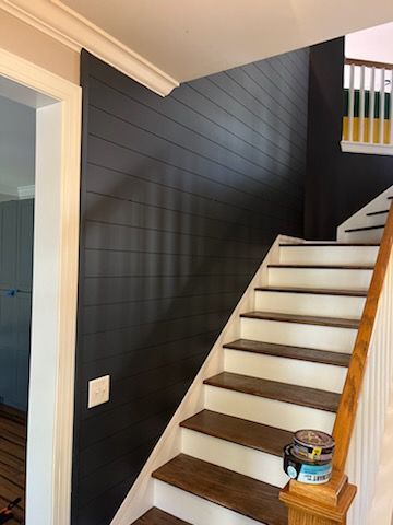 A staircase with black walls and white steps in a house.