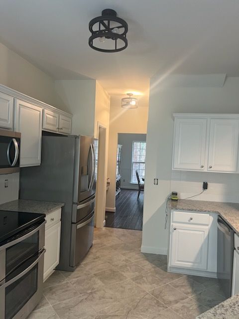 A kitchen with stainless steel appliances and white cabinets