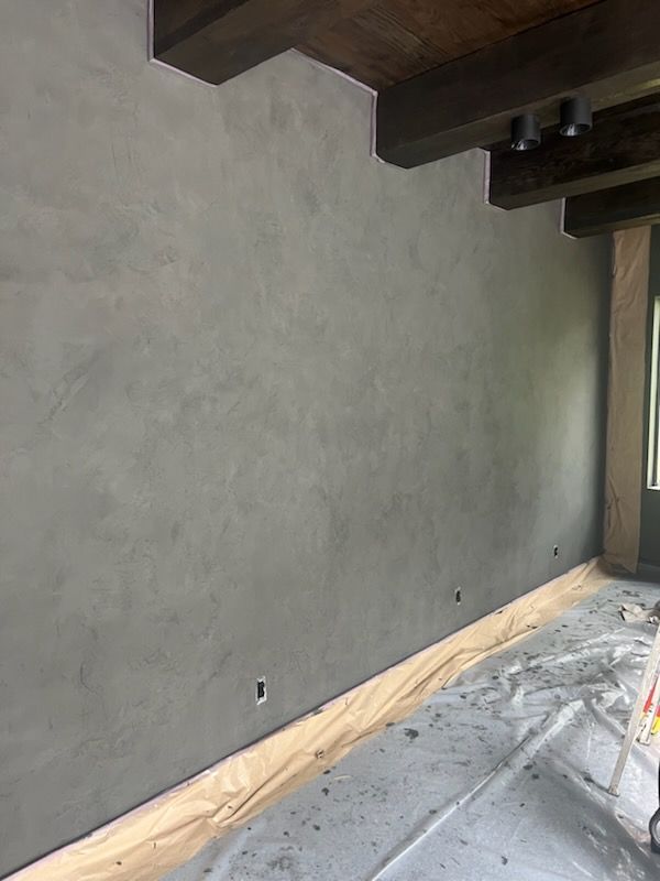 A room with a gray wall and a wooden floor.
