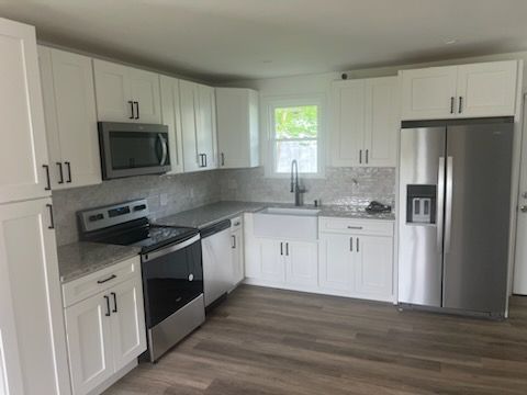 A kitchen with white cabinets and stainless steel appliances.