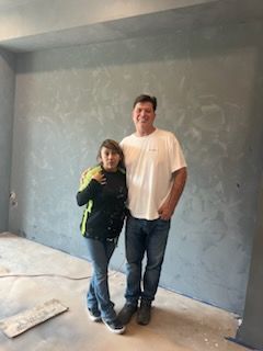 A man and a woman are standing next to each other in an empty room.
