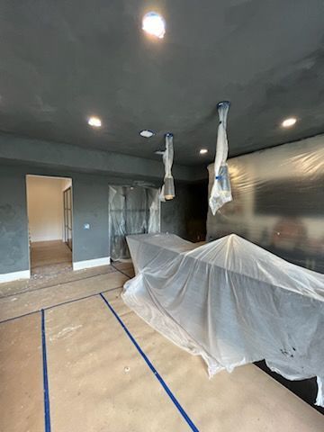 A room with a boat covered in plastic.