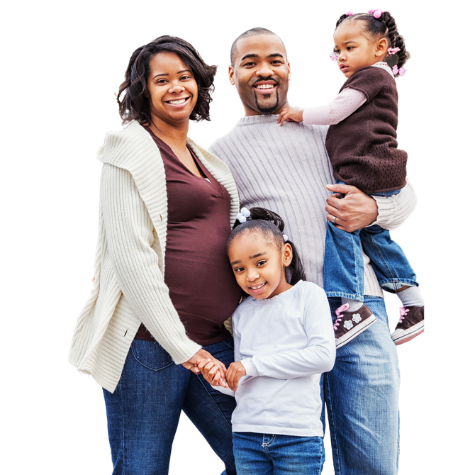 Family of four standing smiling at the camera, looking healthy and happy..
