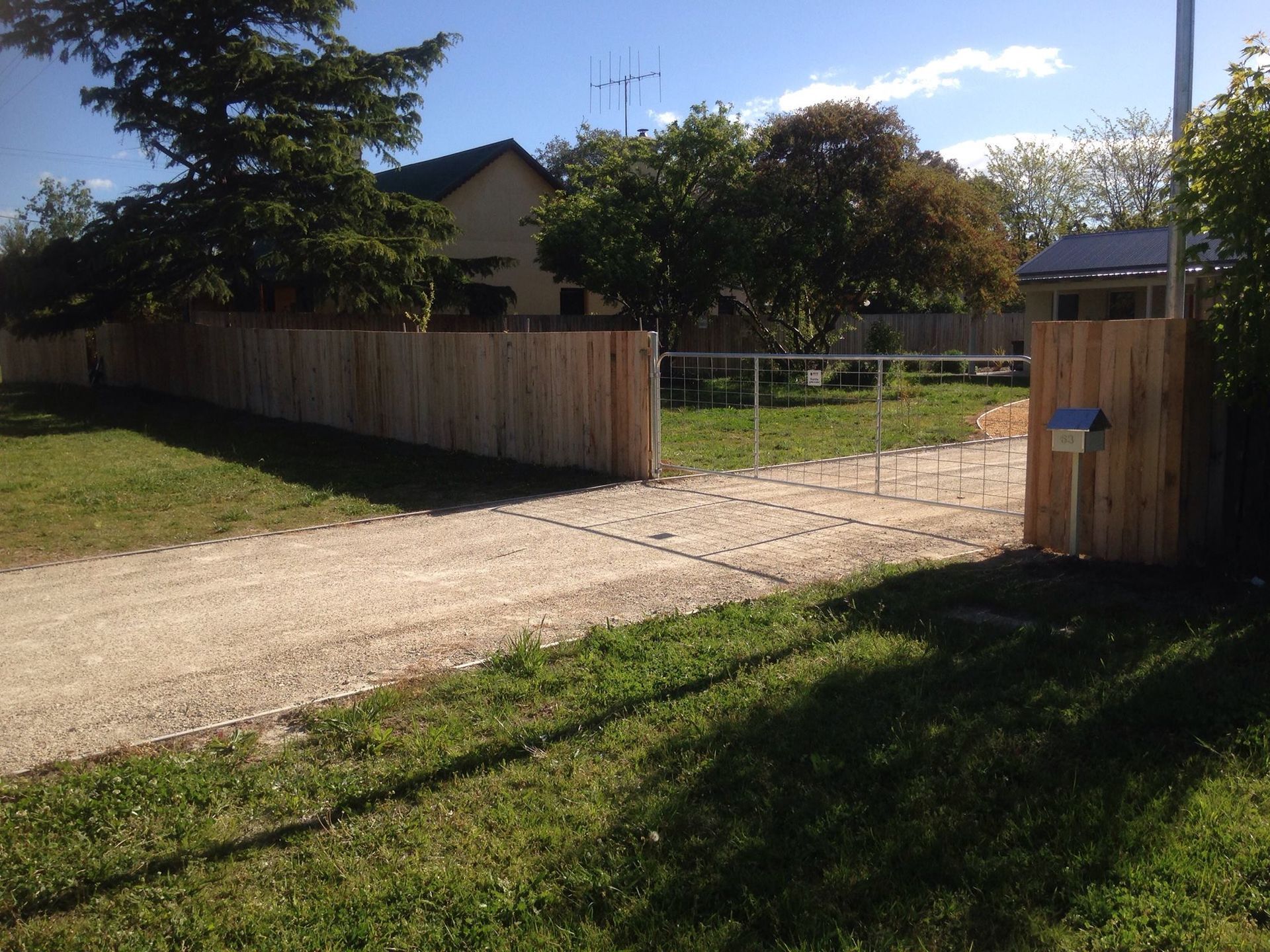 A wooden fence along the side of a dirt road